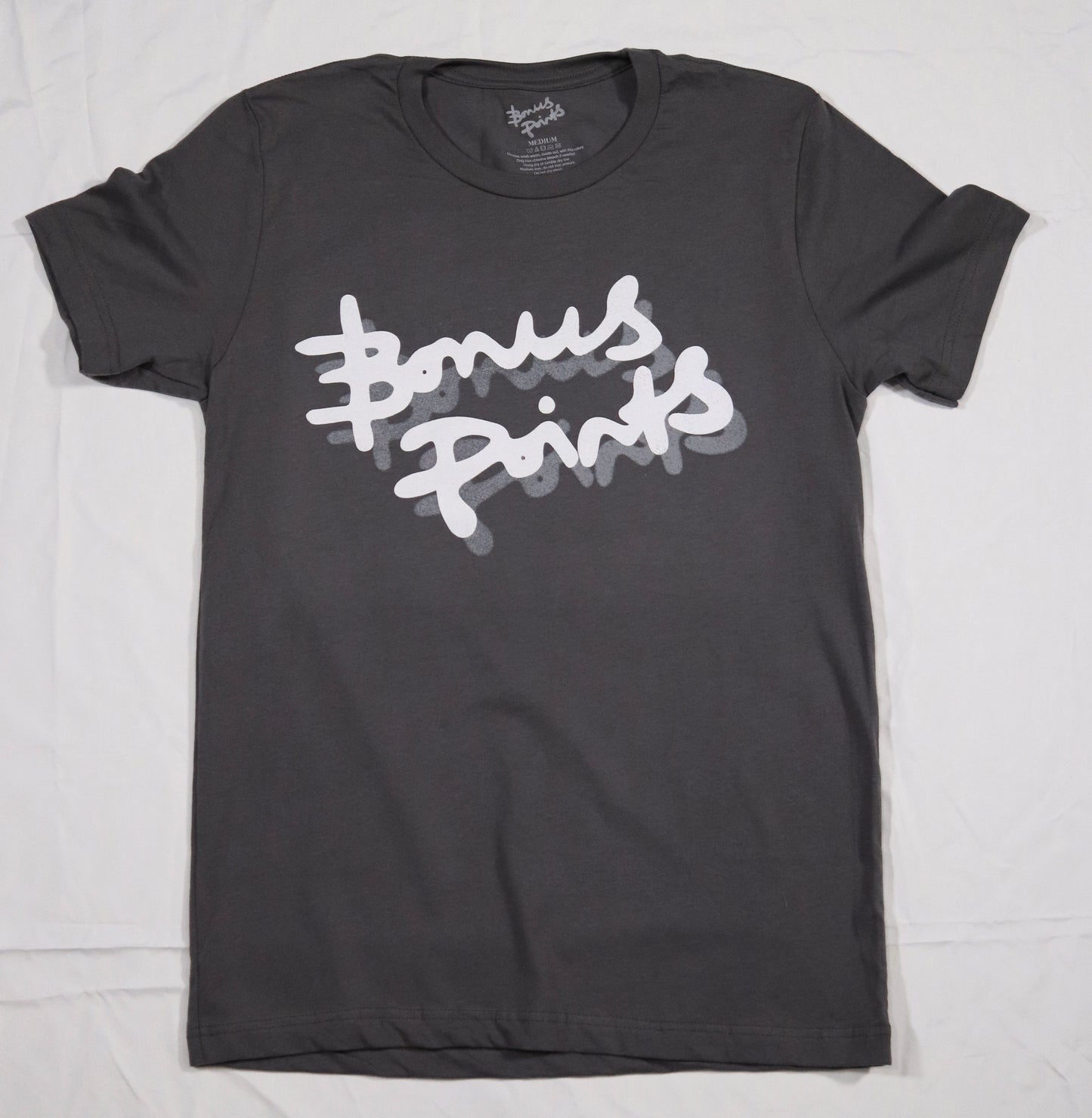 Flat lay of a Gray T-shirt in a soft fabric, displayed on a clean white background. The T-shirt features the Bonus Points Logo across the chest in white ink, with a gray drop shadow.